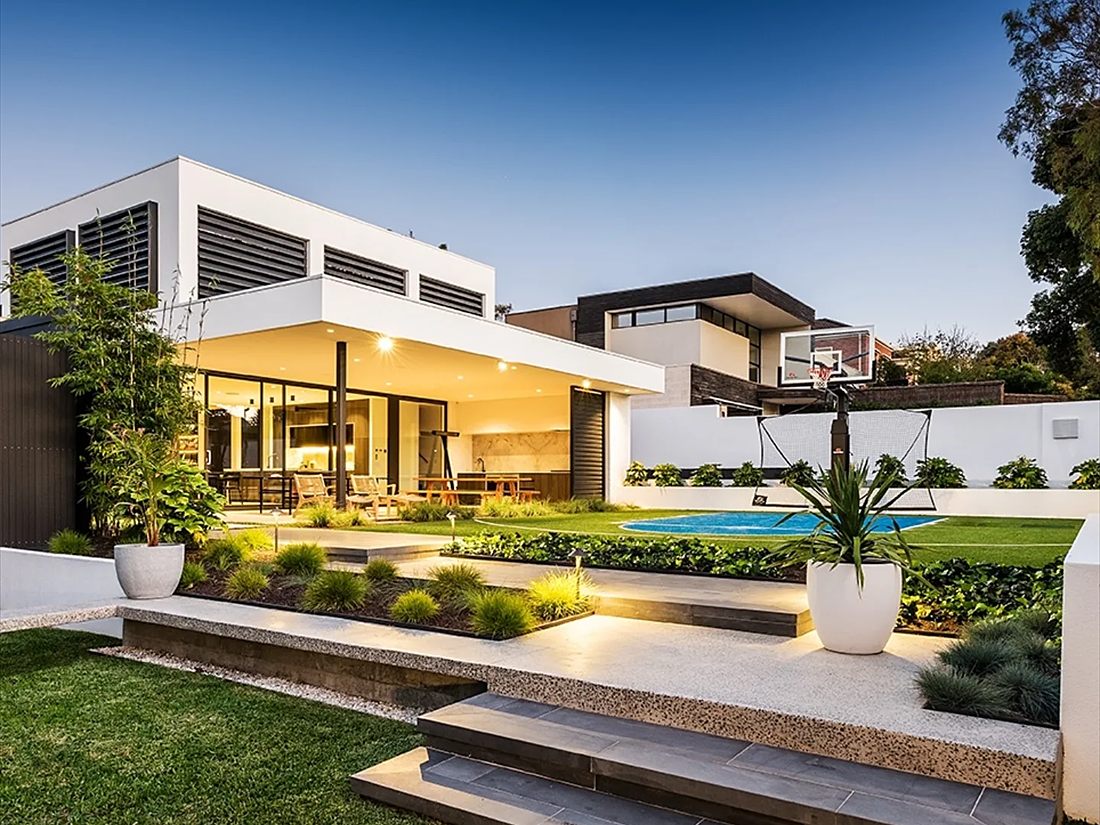 Rendered modern home lit at dusk, with alfresco area, lawn and pool