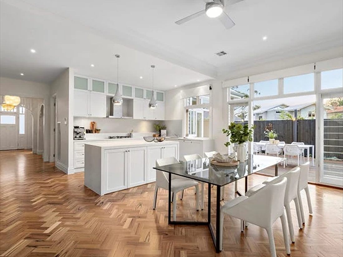 White kitchen and dining room above a herringbone parquet floor