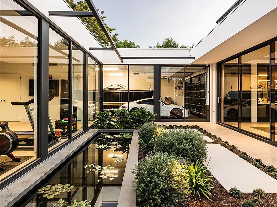 Glazed courtyard with a reflection pond and planted garden beds