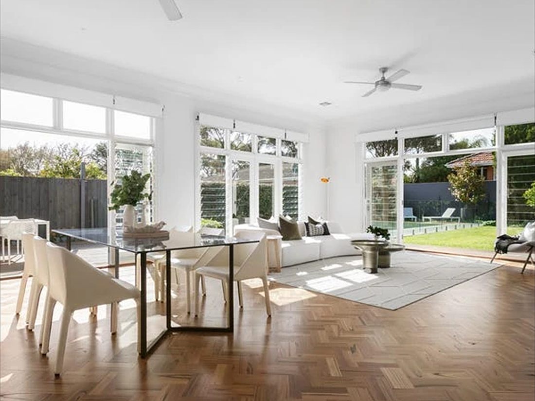 Open-plan living and dining room in white, with windows onto the garden